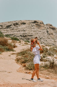 Side view of woman standing on land against clear sky