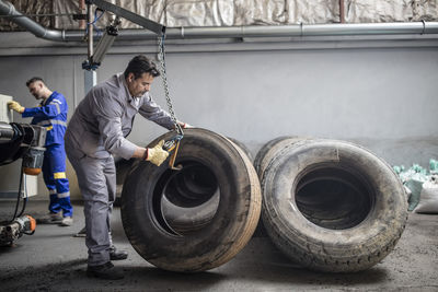 Tire repairer checking tire in factory