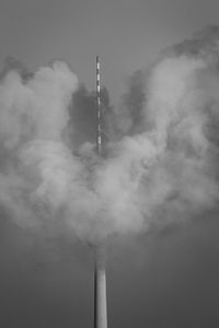 Fernsehturm covered with smoke against sky