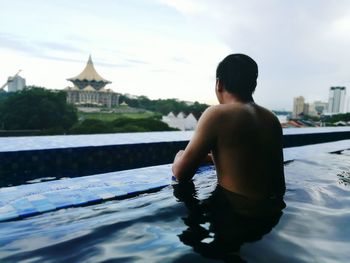 Rear view of shirtless man in water