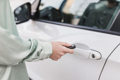 Woman opening car door with remote key