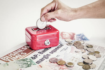 Close-up of hand with tattoo on table against white background