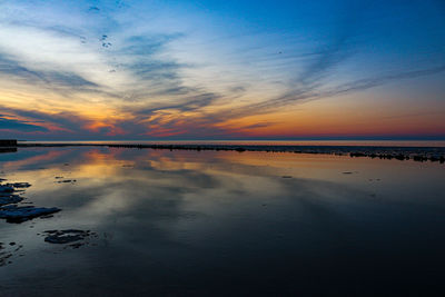 Scenic view of beach against sky during sunset