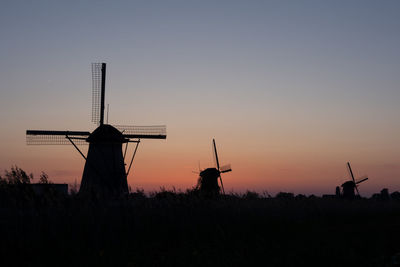 Beautiful wooden windmills at sunset in the dutch village of kinderdijk. windmills run on the wind.