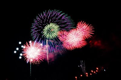 Low angle view of firework display at night
