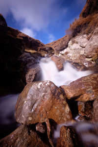 Scenic view of waterfall against sky