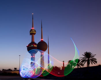 Communications tower in city against clear blue sky