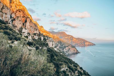 Scenic view of sea and mountains against sky