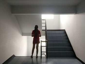 Rear view of woman standing on staircase