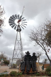 Traditional windmill on field against sky