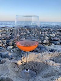 Close-up of drink on beach against sky