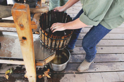 Low section of man making cider