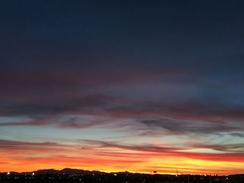 Silhouette city against sky at sunset