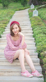 Portrait of smiling woman sitting on staircase