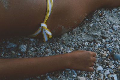 Cropped image of woman wearing bikini lying at beach