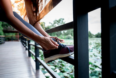 Low section of woman holding railing