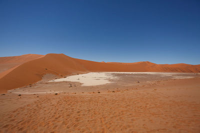 Scenic view of desert against clear blue sky