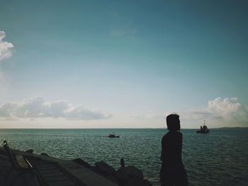 Silhouette woman by sea against sky