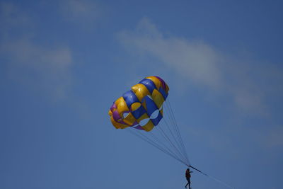 Low angle view of multi colored balloons against blue sky