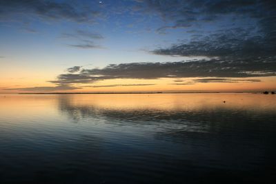 Reflection of clouds in sea at sunset