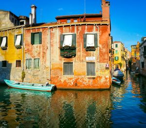 Boats in canal along buildings