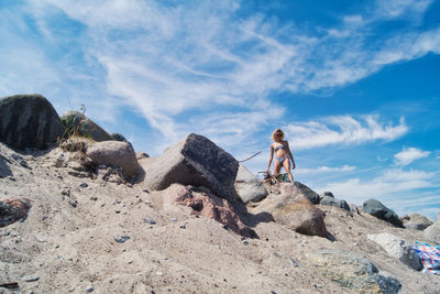 Man standing on rock against sky