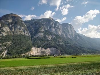 Scenic view of field and mountains against sky