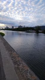Scenic view of river by city against sky