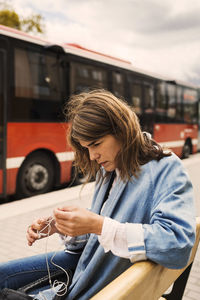 Young woman using mobile phone in bus