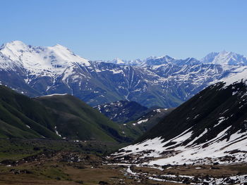 Scenic view of snowcapped mountains against clear blue sky