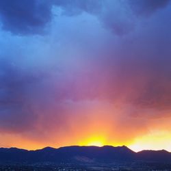 Scenic view of dramatic sky over silhouette landscape