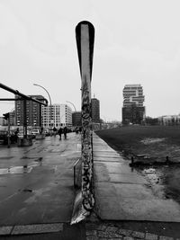 Street by buildings against sky in city