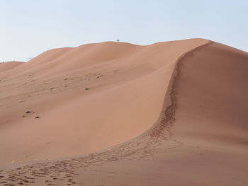 Sand dunes in desert against clear sky