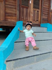 Full length of cute girl standing on staircase