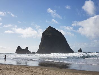 Rock formations on beach against sky