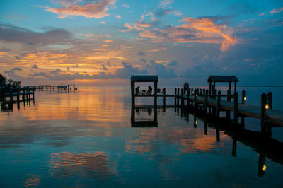 Pier over sea against sky during sunset