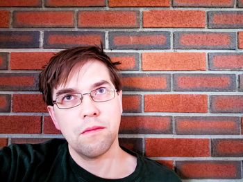 Portrait of a teenage boy against brick wall