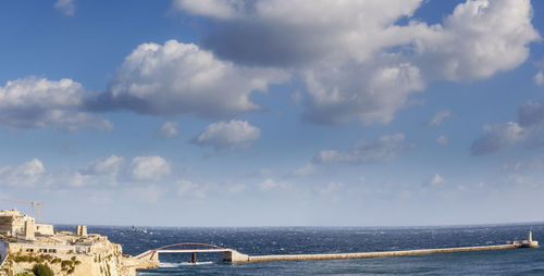 Panoramic view of city by sea against sky