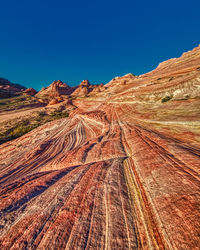Scenic view of desert against clear blue sky