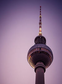 Low angle view of communications tower against sky in city