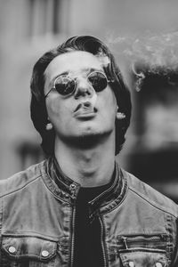 Close-up portrait of young man smoking outdoors