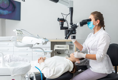 Side view of doctor examining patient in clinic