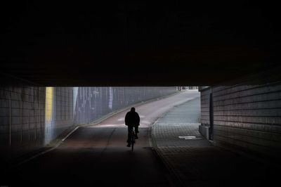 Rear view of silhouette woman walking on road