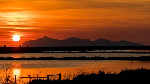 Scenic view of lake against romantic sky at sunset