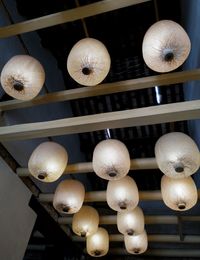 Low angle view of illuminated pendant lights hanging from ceiling