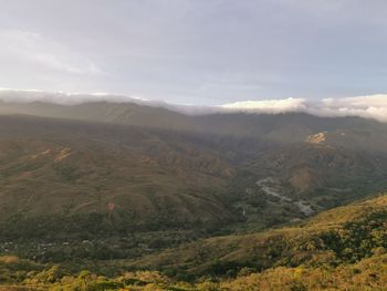 Scenic view of valley and mountains against sky