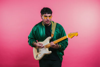 Man playing guitar against yellow background