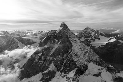 Scenic view of snowcapped mountain against cloudy sky