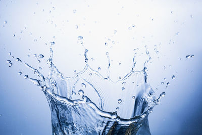 Close-up of wet glass against blue background