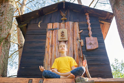 Rear view of man sitting on roof